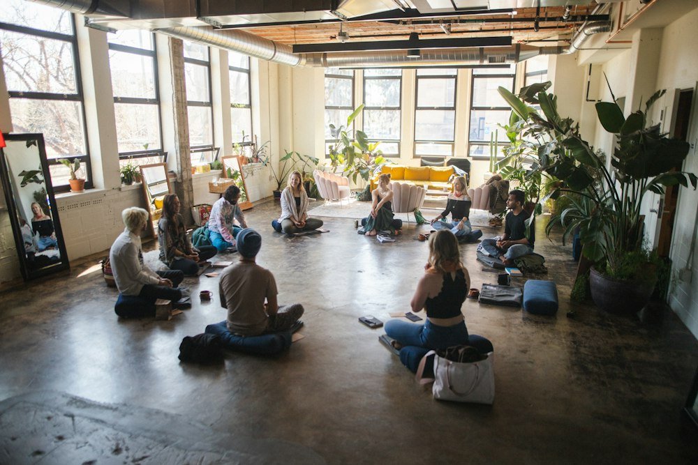 Students gathered for a yoga class in a bright, plant-filled studio